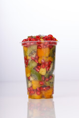 Mixed cut fruits arranged in a transparent tableware , isolated.