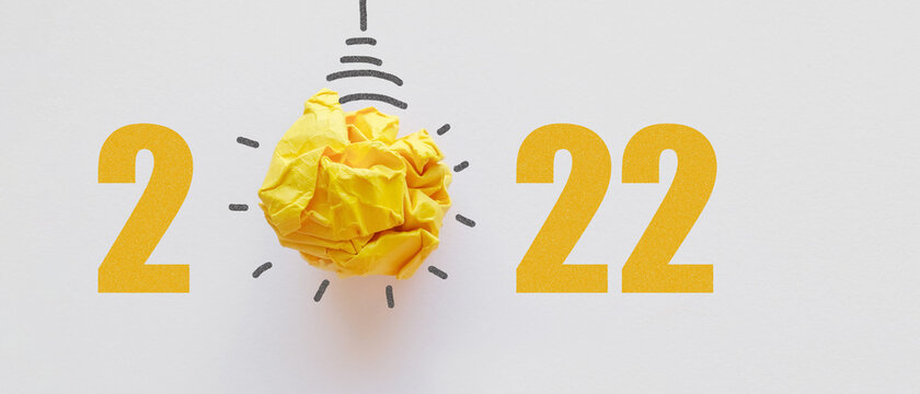 2022 Yellow paper light bulb, innovative business vision and new year goal resolution concept