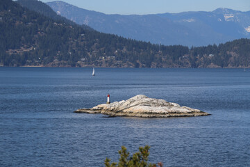 Obraz premium A small lighthouse on the edge of a rock island