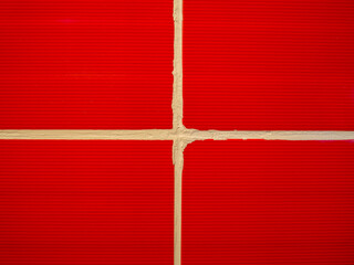 Red ceramic tiles separated by a white gap in a cross