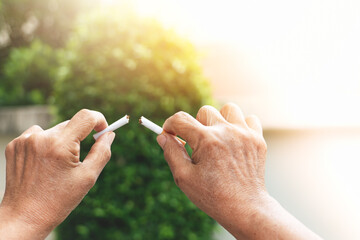 Quit smoking, no tobacco day, mother hands breaking the cigarette