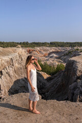 Naklejka premium A beautiful woman on the background of landscape.Top view of the quarry