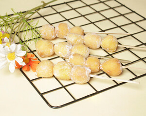 Sate donuts sprinkled with powdered sugar. Sweet snacks with a soft texture are loved by small children to adults. Perfect for serving at parties. Market snacks. Mini cake. Focus blur.