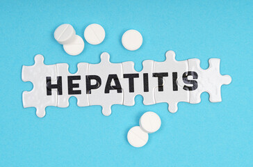 On a blue background pills and puzzles with the inscription - hepatitis