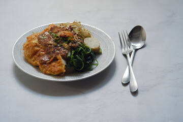 rice cake served with vegetables and peanut sauce in a plate 