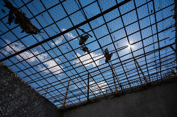 View of the blue sky through the bars of the prison cell