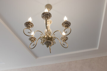 chandelier in a modern style with glowing bulbs contours and curves for a large house