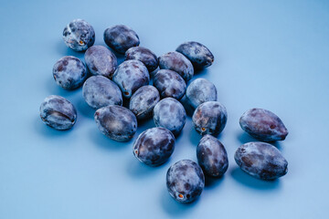Plums on a blue background close-up top view.