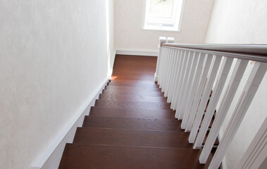 wooden staircase with brown treads and white risers and balusters
