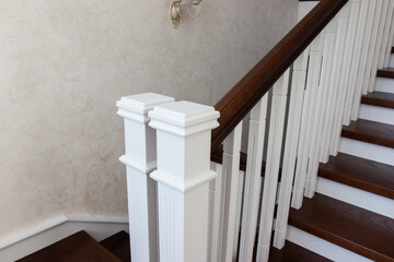wooden staircase with brown treads and white risers and balusters