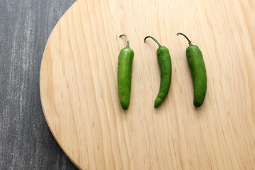 Variety of fresh vegetables in basket and chopping board ready to cook a Mexican sauce: onion, tomato, green chilies
