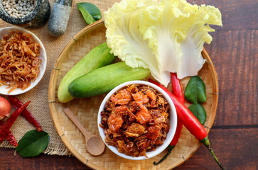 Thai Southern style fried shrimp chili paste - Phuket style chili paste and in Thai called Nam Prik Koong Siep with vegetables and some ingredients flat lay on wood table