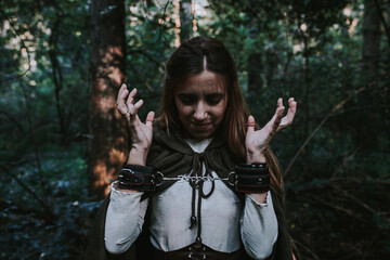 girl in a historical dress in a coniferous forest