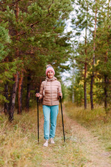 Obraz premium an elderly woman in sportswear with sticks