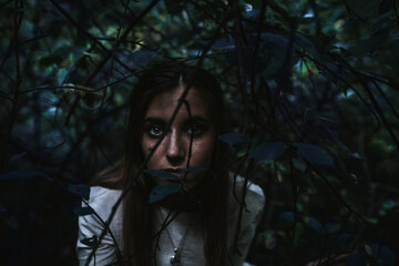 girl in a historical dress in a coniferous forest