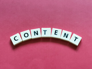 Word CONTENT center placed lettering created using square letter tiles isolated on red background.