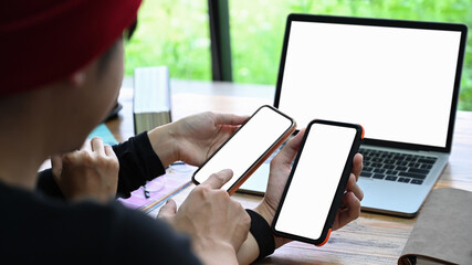 Young man sharing information on smart to his colleague.