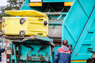 A garbage truck picks up garbage in a residential area. Separate collection and disposal of garbage. Garbage collection vehicle.