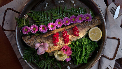 Fototapeta na wymiar Fried Fish garnished with fruits and flowers