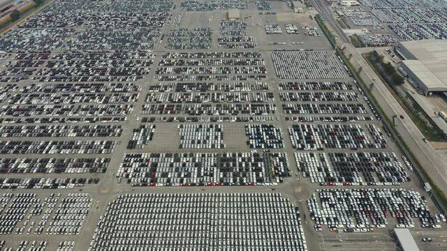 Aerial view of new cars at the automotive plant. Automobile and automotive industry distribution logistic.