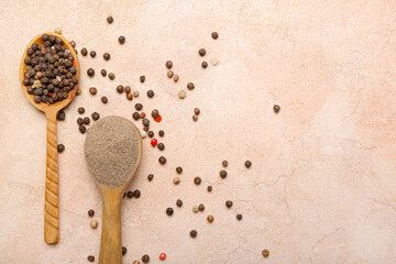 Spoons with black peppercorns and powder on color background