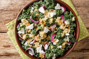 Vegetarian salad with quinoa, onions, kale, feta and almonds dressed with vegetable oil close-up in...