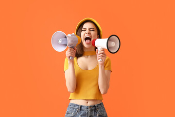 Fototapeta na wymiar Protesting young woman with megaphones on color background