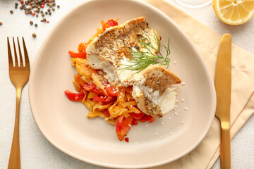 Plate with tasty baked cod fillet, vegetables and sauce on light background