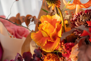 original autumn bouquet of roses, chrysanthemums, leaves of trees and berries