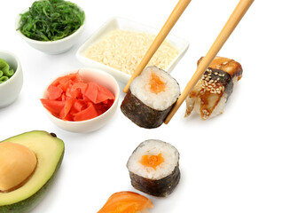 Chopsticks taking maki roll with salmon, closeup