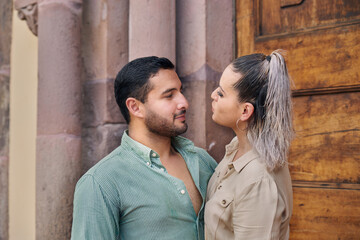 Young Latino male and female couple looking at each other in love between 25 and 35 years of age.