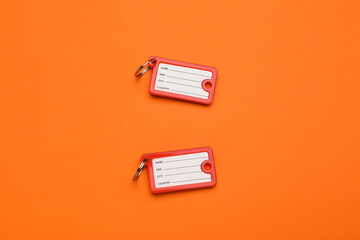New plastic key tags on orange background