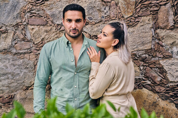 Young Latino male and female couple looking at each other in love between 25 and 35 years of age.