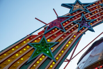 Obraz na płótnie Canvas broken stars on old amusement park ride lights colorful bulbs