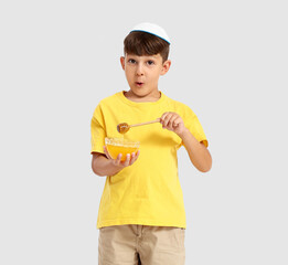 Little boy with honey on white background. Rosh Hashanah (Jewish New Year) celebration