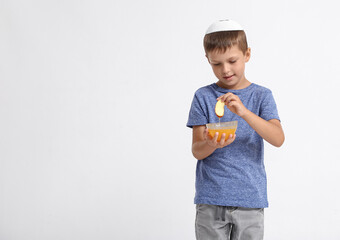 Little boy with honey and apple on white background. Rosh Hashanah (Jewish New Year) celebration