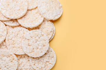 Puffed crispy rice crackers on color background