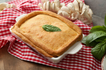 Baking dish with tasty mushroom pot pie on table