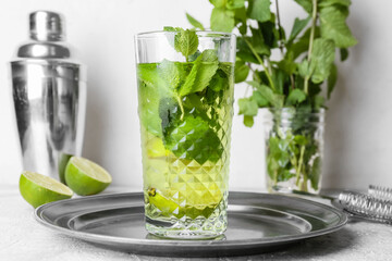 Glass of tasty mint tea with lime on white table