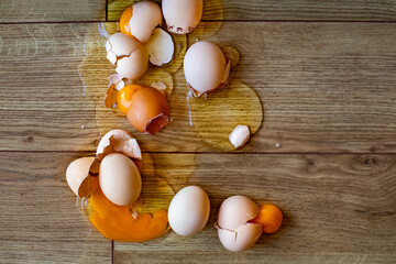 Many eggs fall down to the floor and broken. An accident in the kitchen. 