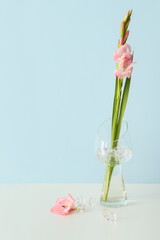 Vase with gladiolus flowers on table in room
