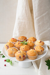 Stand with tasty cranberry muffins on table
