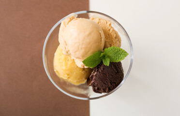 Bowl of delicious different ice cream balls on color background