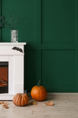 Fototapeta premium Fireplace decorated for Halloween party near color wall in room