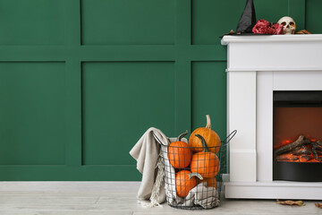 Fireplace decorated for Halloween party near color wall in room