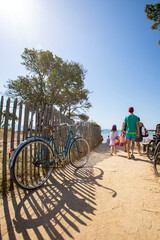 Famille de vacanciers en France allant à la plage en été.