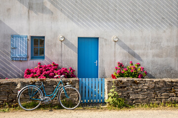 Vieux vélo bleu le long d'une maison dans les rues de l'île de Noirmoutier en Vendée, France.