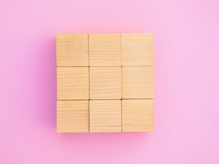 Nine wooden blocks in the form of the square on the pink background, business team concept.