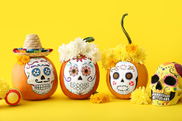 Pumpkins with painted skull on color background. Celebration of Mexico's Day of the Dead (El Dia de...