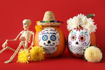 Pumpkins with painted skull on color background. Celebration of Mexico's Day of the Dead (El Dia de...